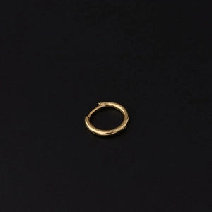 Close-up of a polished gold hoop earring with a smooth glossy finish on a dark background