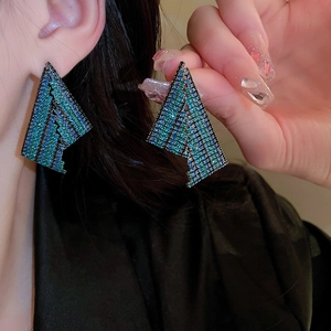 Detail view of geometric triangle tassel earrings with blue-green gradient rhinestones