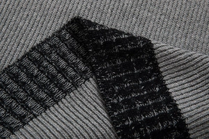 Macro della trama a maglia a contrasto grigio e nero su un maglione da uomo
