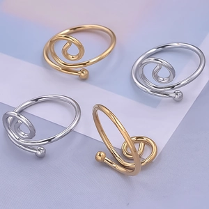 Macro shot of gold and silver irregular spiral 304 stainless steel rings on purple fabric