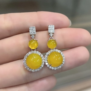 Detailed view of elegant silver earrings featuring round yellow chalcedony gemstones