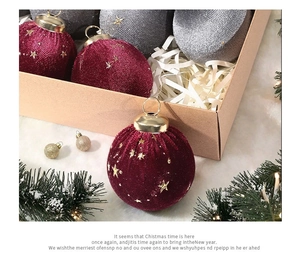 Close-up of velvet Christmas ornaments with gold star embroidery in festive gift box