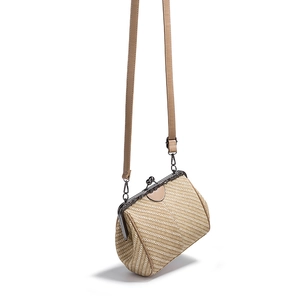 Detail of beige woven crossbody bag with leather strap and metal clasp closure