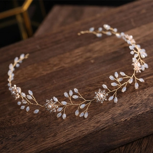 Exquisite gold floral crystal headband with pearls and rhinestones on dark wood surface