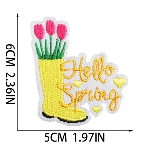 Detailed close-up of yellow rain boot embroidery patch with tulips and Hello Spring text