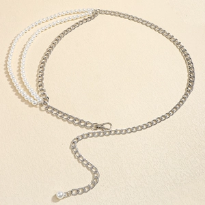 Detail of silver metal chain belt featuring layered white pearls and lobster clasp