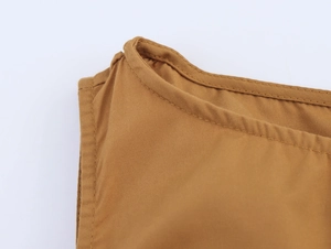Close-up of brown cotton linen sleeveless dress showing neckline stitching and texture