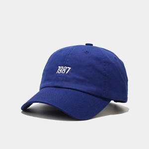 Detailed view of royal blue cotton baseball cap featuring 1987 embroidery and curved brim