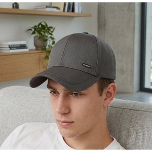 Detail der dunkelgrauen Baseballkappe mit Premium-Metalllogo und Twill-Stoffstruktur