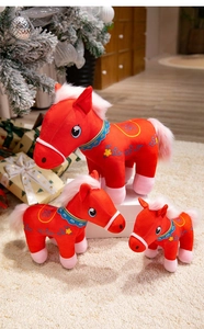 Detailed set of red plush horse dolls with ethnic embroidery in festive room decor