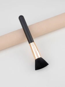 Macro shot of fluffy black bristles and rose gold ferrule on a makeup brush