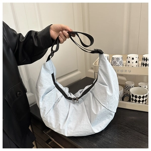 Détail du sac hobo bleu clair montrant le nylon plissé et la double fermeture éclair