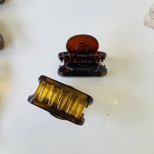 Detail view of tortoiseshell resin hair clips in round brown and amber rectangle styles