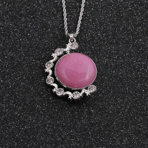 Nahaufnahme des Mond-Stern-Anhängers mit rosa Edelstein an silberner Kordelkette