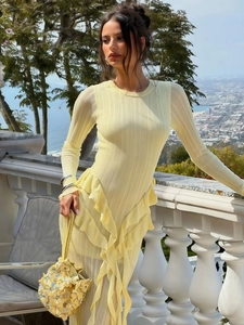 Détail de la robe côtelée jaune clair avec volants élégants et un sac à main fleuri