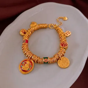 Elegant gold plated Chinese Fu character bracelet with cultural charms and red enamel beads