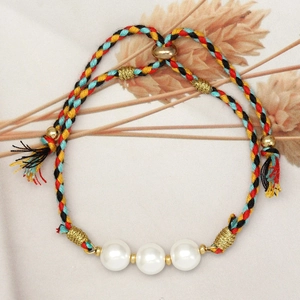 Macro detail of handmade woven rope pearl bracelet with adjustable golden slider clasp