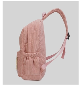Side view of pink corduroy backpack showing padded straps and storage pocket detail