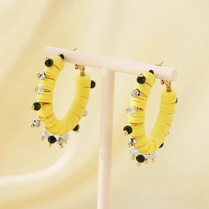 Détails de boucles d'oreilles créoles perles Heishi jaunes sur support à bijoux rose