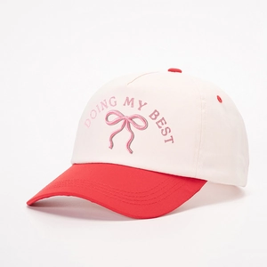 Two-tone baseball cap in off-white and red with Doing My Best bow embroidery