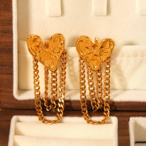 Macro shot of 18K gold-plated stainless steel hammered heart earrings with chain tassels