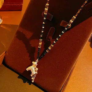 Tijgeroog kralenketting met vergulde paardenhanger op een fluwelen standaard