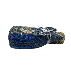 Macro detail of wine bottle crystal clutch with blue rhinestones and bow accent