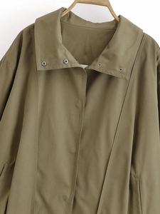 Detail view of army green bomber jacket collar with metal snap buttons on wood hanger