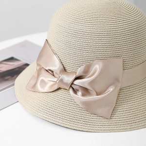 Détail d'un chapeau de soleil en paille avec un grand nœud en satin élégant et brillant
