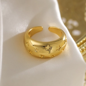 Minimalist gold open ring with engraved star patterns on polished metal surface