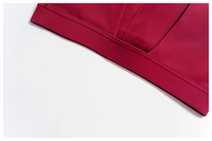 Detailed macro shot of the double-stitched hem on a dark red yoga sports bra