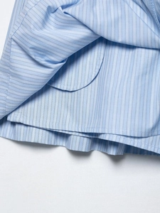 Détails de rayures verticales bleu clair sur tissu en coton avec coutures fines et texture