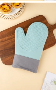 Detail of teal silicone heat resistant oven mitt with grey fabric cuff on wood