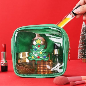 Close-up of green chenille makeup bag with Christmas tree embroidery patch detail