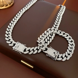 Detail of silver Cuban chain necklace and bracelet set with sparkling rhinestones