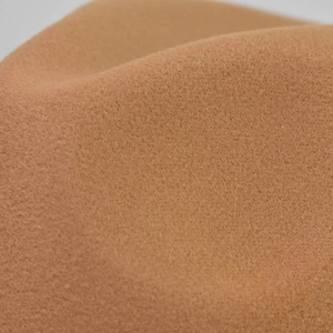Close-up detail of high-quality camel wool felt fabric with soft texture and rich fiber density