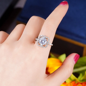 Detail van een zilveren bloemring met een ronde diamant en pave-gezette band