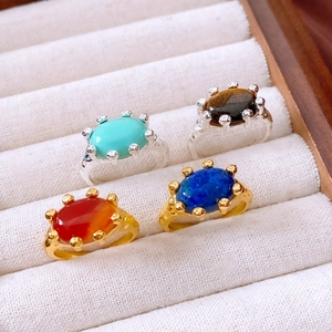 Detail of vintage 18K gold plated rings with oval turquoise and tiger eye stones