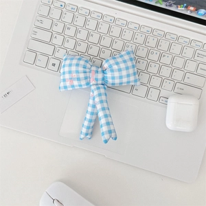 Blue and white plaid bow accessory with pink floral patterns on a laptop keyboard