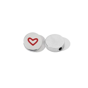 Macro detail of silver stainless steel flat bead with red heart and side hole