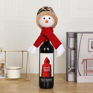 Detail of snowman wine bottle cover with red knit scarf and plaid plush hat decoration