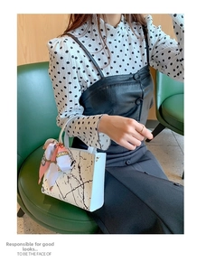 Chic white handbag with marble pattern and silk scarf shown in a lifestyle setting