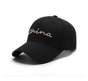 Detail view of gold cursive China embroidery on a black cotton baseball cap fabric