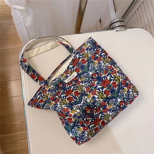 Macro detail of retro floral cotton handbag with zip closure and simple wish label
