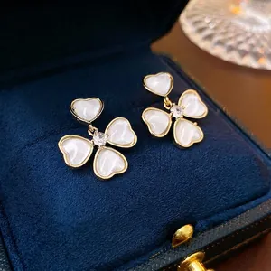 Elegant gold plated flower stud earrings with white heart petals and zircon centers