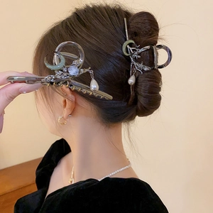 Détail de pinces à cheveux en métal avec breloques lune croissant étoile et perle
