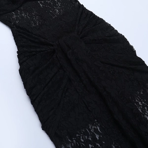 Detailed view of black sheer lace dress showing intricate waist pleats and floral patterns