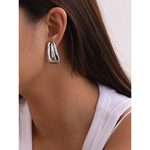 Boucles d'oreilles trapèze géométriques en acier inoxydable poli portées par un mannequin