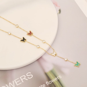 Detail of gold necklace featuring colorful butterfly pendants and sparkling crystal accents