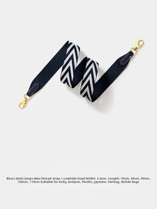 Detail of blue and white chevron canvas bag strap with leather ends and gold metal buckle